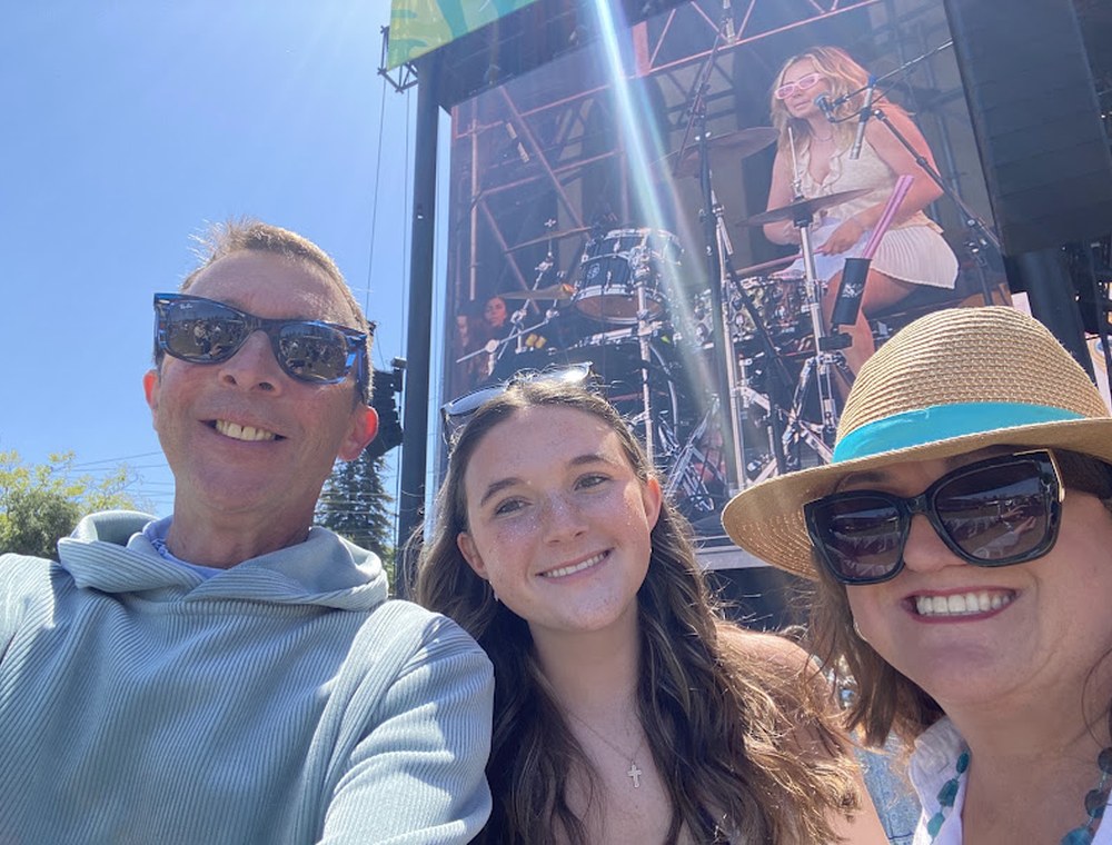Sean, his wife, and daughter at an outdoor concert
